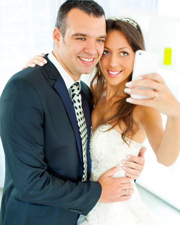 Couple using smartphone on wedding day