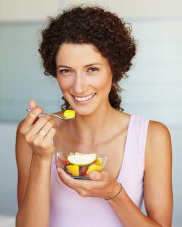 Woman eating fruit salad