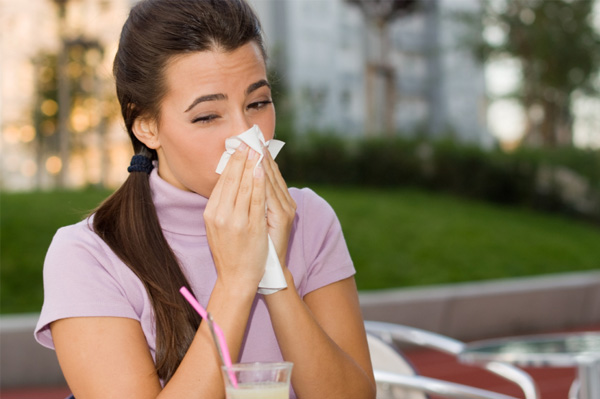 Woman sneezing outdoors