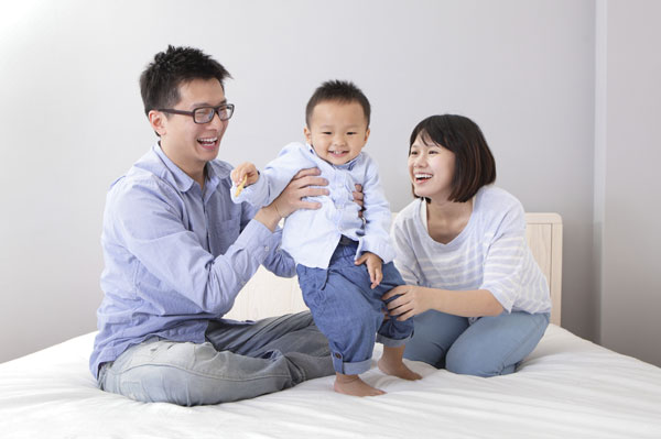 Happy family on bed together laughing