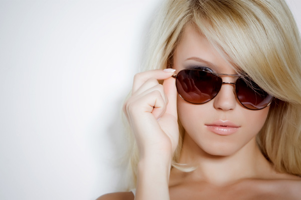 Woman putting on sunglasses