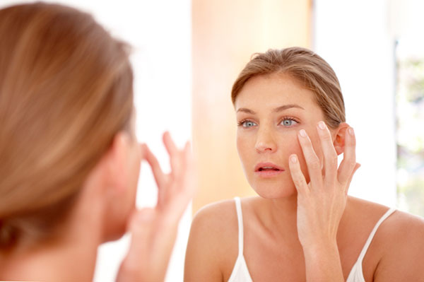 Woman looking at her skin in a mirror