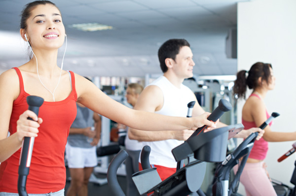 Woman using elliptical at gym