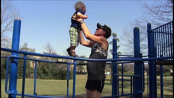 Dad doing playground exercises with toddler