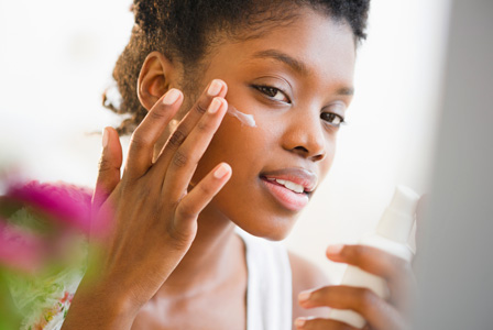 Woman putting on facial lotion