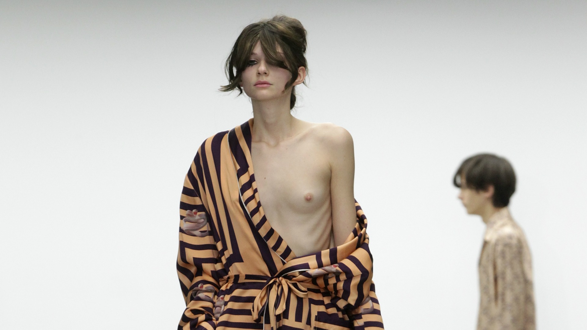 Katie Eary model struts down the runway with her breasts on full display