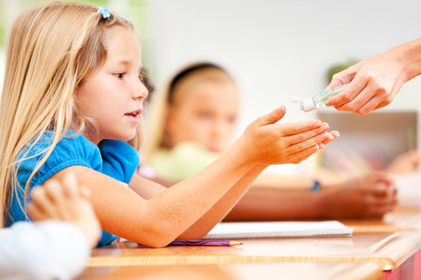 Child Applying Hand Sanitizer in School