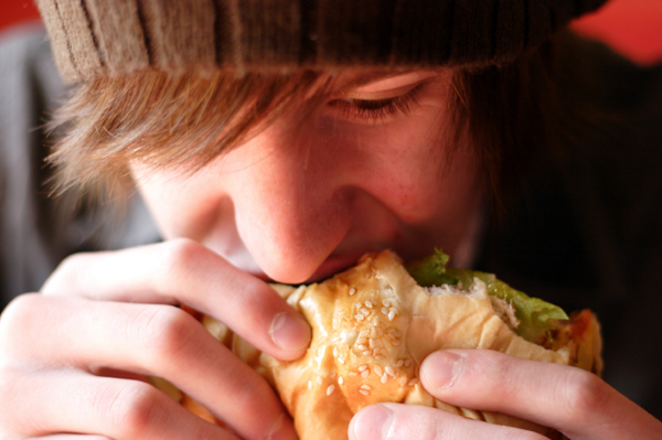 fat person eating burger. fat man eating burger.