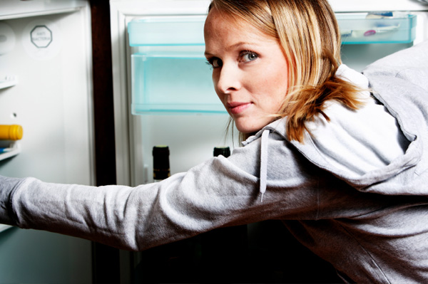 College Girl Looking in to Refrigerator