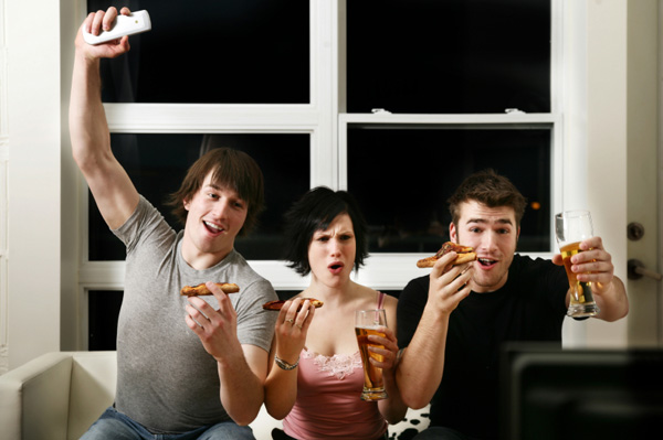 Friends watching football and eating pizza.