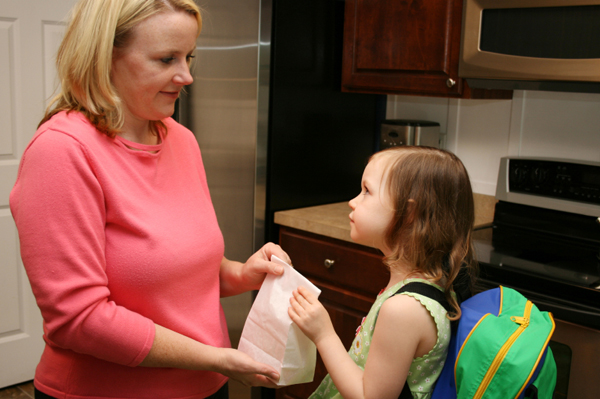 Mom Handing Daughter Lunchbox