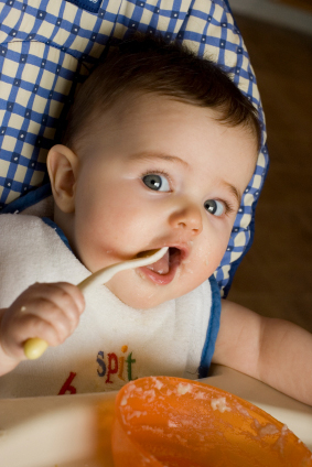 baby in high chair eating puree
