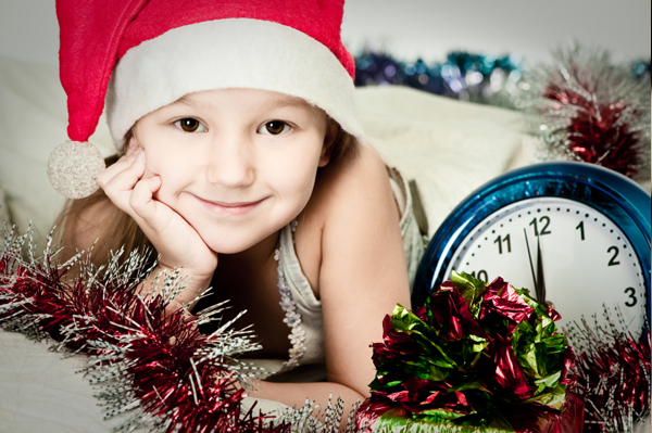 Little girl with clock on New Year's Eve