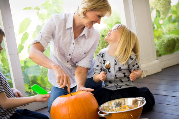 Mom and kids carving pumpking
