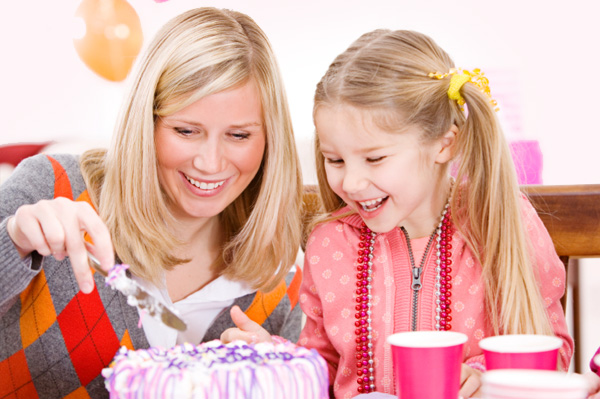 Mother cutting homemade birthday cake