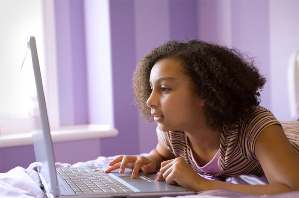 Tween on laptop in bedroom