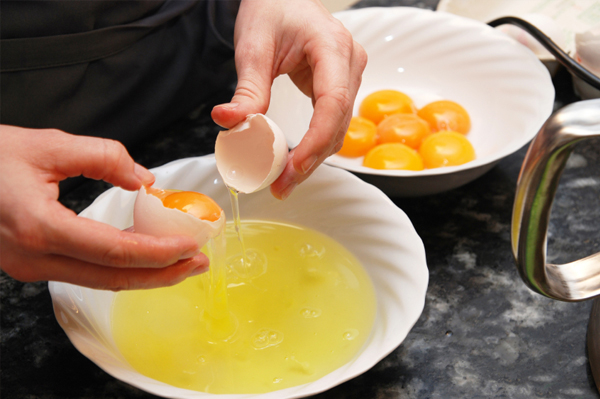 Woman breaking eggs