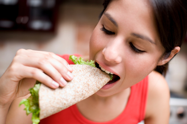 Woman eating whole wheat wrap