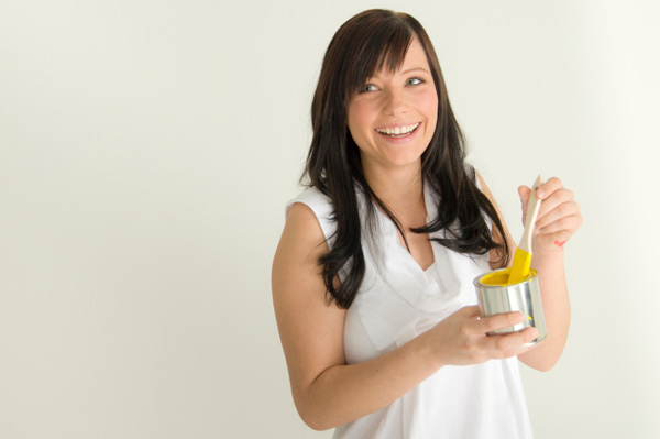 Woman painting walls yellow