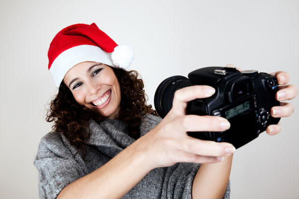 Woman wearing santa hat with camera