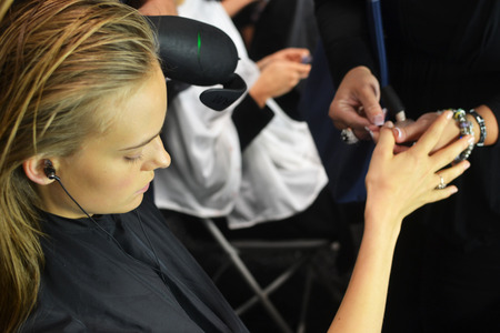 A BCBG model gets her nails painted in Samoan Sand by OPI.