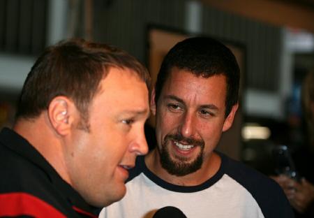Adam Sandler smiling and looking at Kevin James