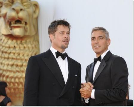Brad Pitt and George Clooney in front of a golden lion while in Venice