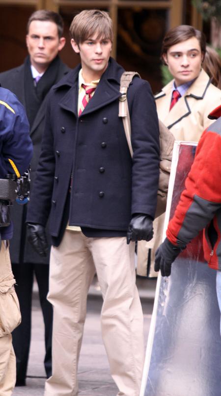Chase Crawford carries a bag next to Ed Westwick on the Gossip Girls set