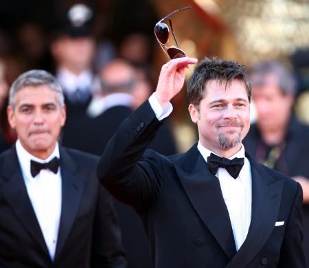 George Clooney with Brad Pitt holding sunglasses at the film festival