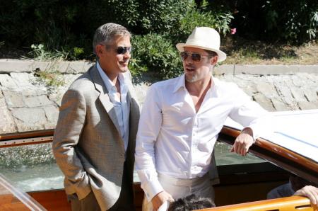 George Clooney leaning with Brad Pitt in Venice