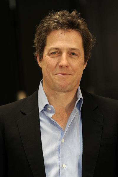Hugh Grant smirks at a photocall for his film 'Did You Hear About the Morgans?' in Germany.