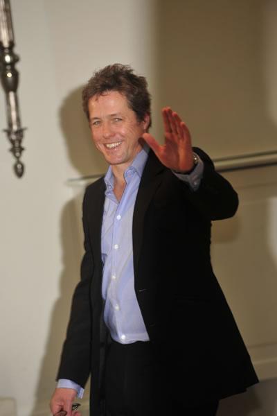 Hugh Grant greets photographers at a photocall for his film 'Did You Hear About the Morgans?' in Rome.