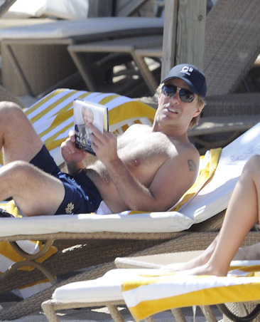 The rockstar is seen sunbathing while reading a book in St Barts