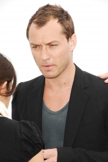 Jude Law has a dark jacket over his grey shirt while in New York