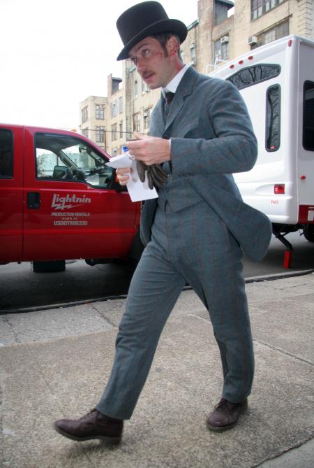 Jude Law walks down the street in Sherlock Holmes