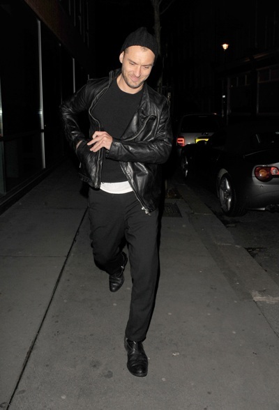 Jude Law struts his stuff in a black leather jacket and beanie
