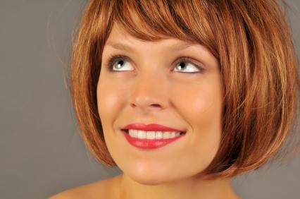 The chin-length bob features side-swept bangs and long layers that frame the 