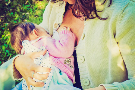 Young woman nursing baby girl | Sheknows.com